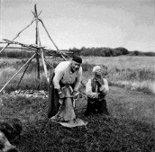 Cree Woman from Canada working on beaming log with her hide