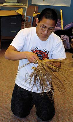 Nolan Murphy of Stebbins coaxes grasses with many loose ends into mats at StebbinsYupik art and dance festival Jan. 29. 